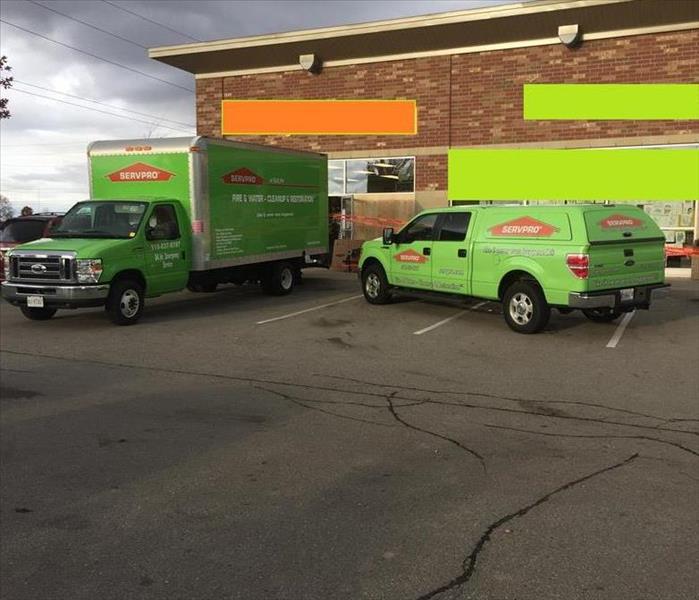 two SERVPRO vehicles in front of a commercial plaza